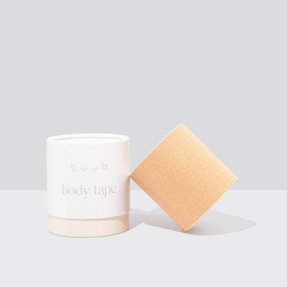 Buub Maxi Body Tape in a light nude colour. The wide roll of boob tape is displayed beside the stylish white and beige 'buub' branded packaging.