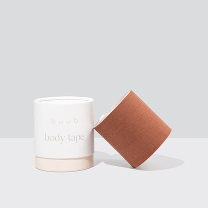 A wide roll of Buub Maxi Body Tape in a versatile tan colour. This adhesive bra solution is shown with its signature white and beige packaging for a clear product view.