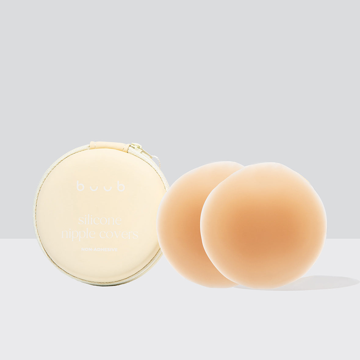 Buub's 8cm reusable non-adhesive silicone nipple covers in tan, perfect for medium skin tones. The product is shown with its signature cream zippered storage case.