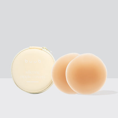Buub's 8cm reusable non-adhesive silicone nipple covers in tan, perfect for medium skin tones. The product is shown with its signature cream zippered storage case.